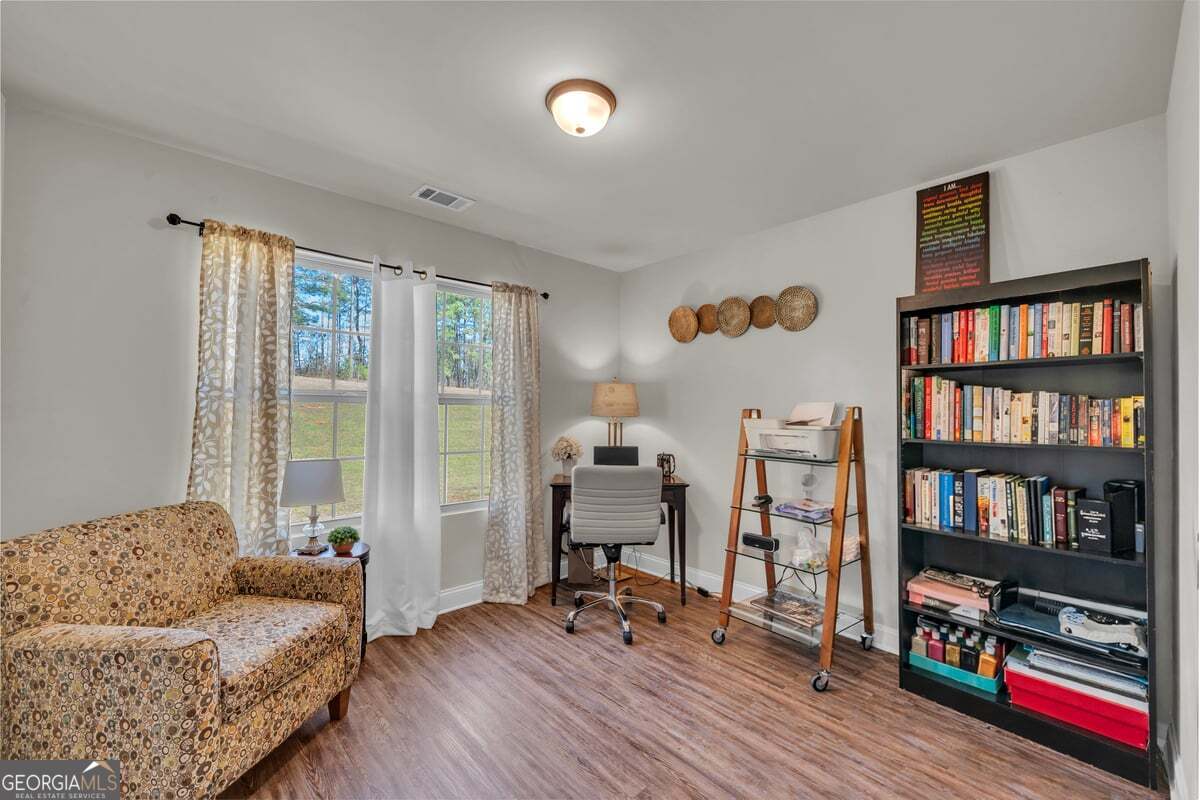 773 Weldon Road Forsyth, GA 31029 - Photo 24 of 37 a living room with furniture and a book shelf