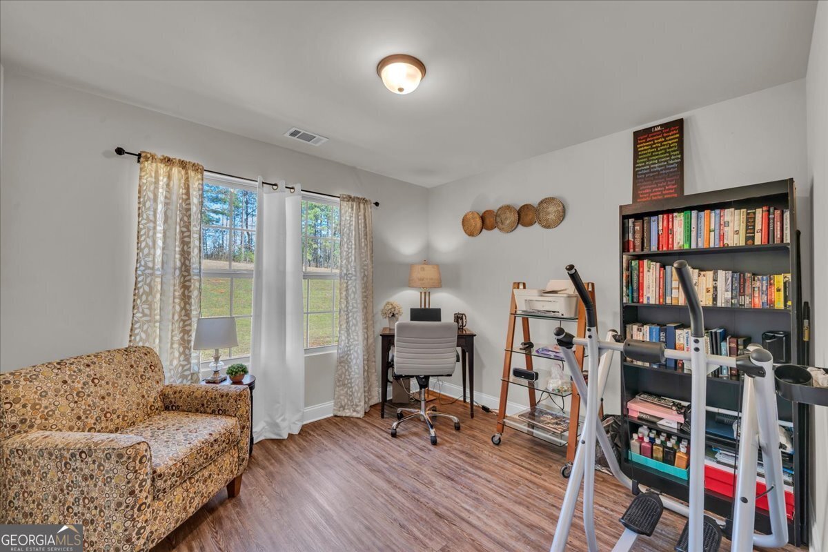 773 Weldon Road Forsyth, GA 31029 - Photo 25 of 37 a living room with lots of furniture and a book shelf
