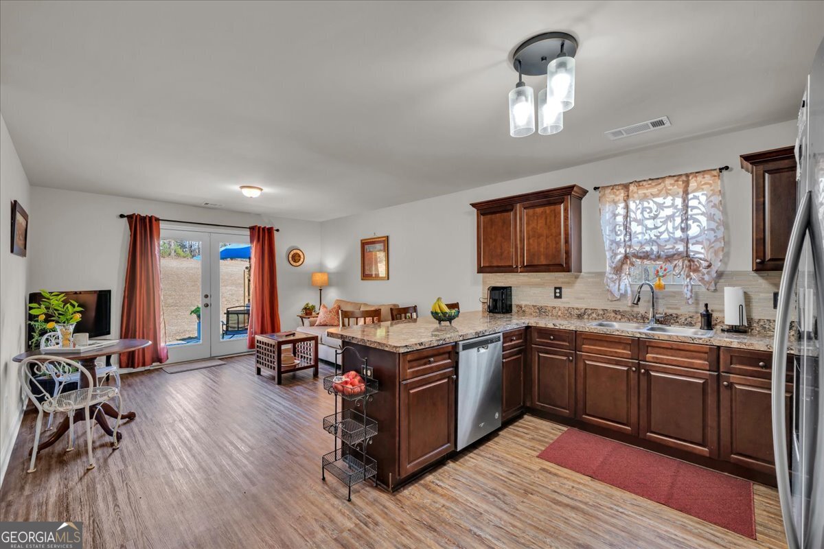 773 Weldon Road Forsyth, GA 31029 - Photo 7 of 37 a kitchen with stainless steel appliances granite countertop wooden floors and view living room
