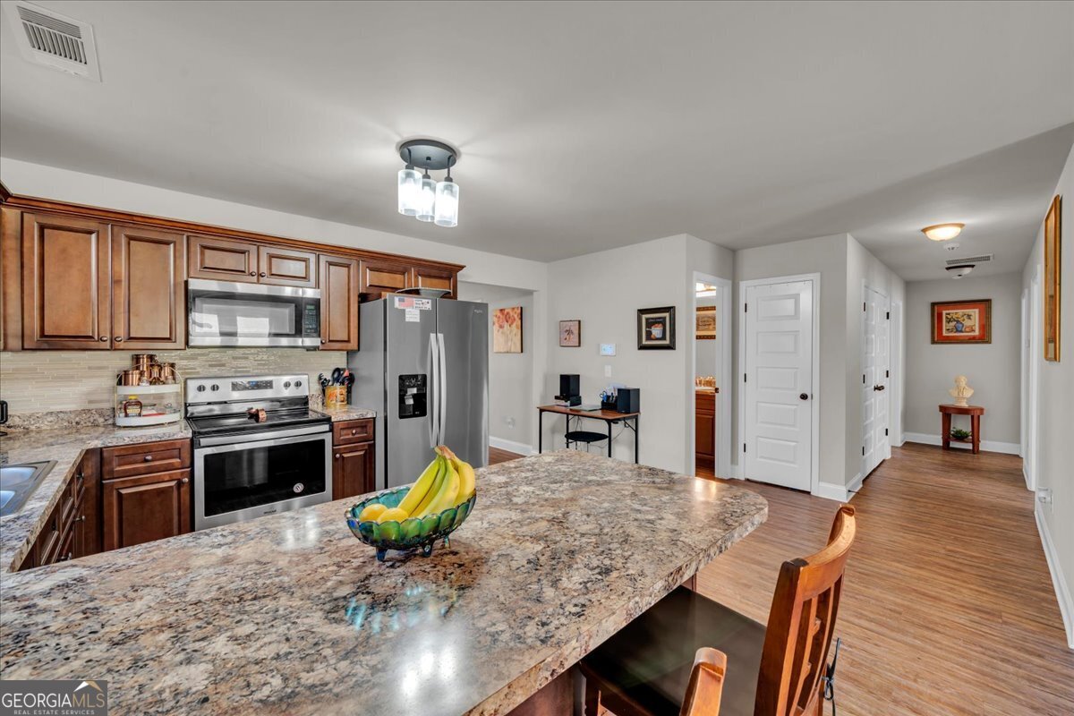 773 Weldon Road Forsyth, GA 31029 - Photo 10 of 37 a view of a dining room with furniture a kitchen and chandelier