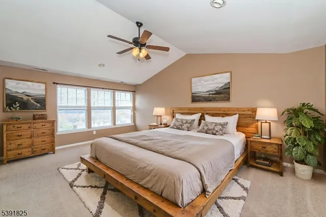 a bedroom with a bed a dresser and a chandelier