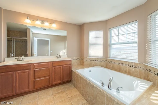 a bathroom with a tub a sink and a window