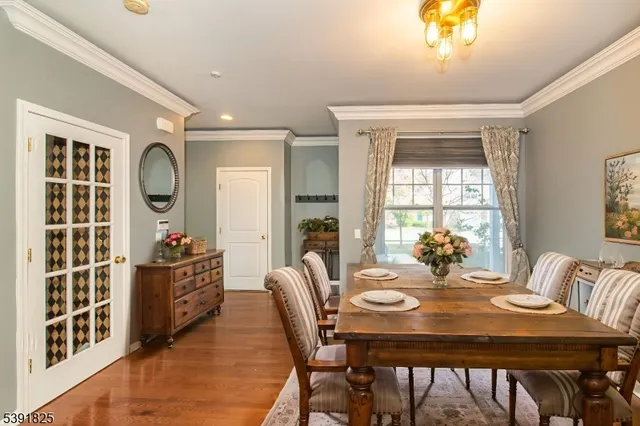 a view of a dining room with furniture a chandelier and wooden floor