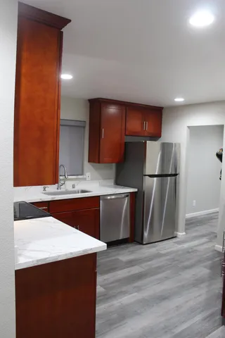 a kitchen with stainless steel appliances granite countertop a sink a refrigerator and a stove