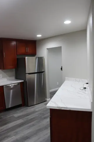 a kitchen with granite countertop a refrigerator and a sink