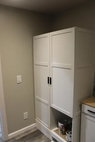 a white refrigerator freezer and a wooden floor
