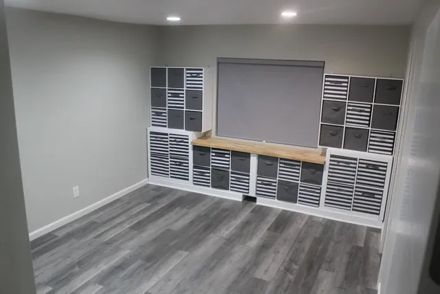 a view of empty room with wooden floor and windows