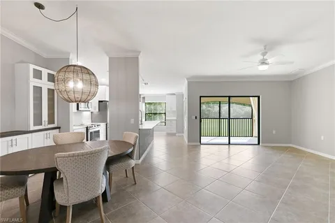 a dining room with furniture a chandelier and window
