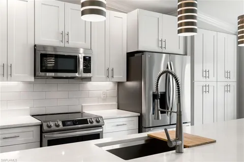 a kitchen with stainless steel appliances a sink stove and refrigerator