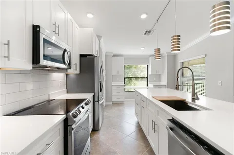 a kitchen with a window and cabinets