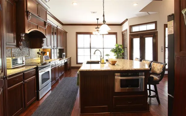 a kitchen with kitchen island granite countertop a stove a sink and a refrigerator