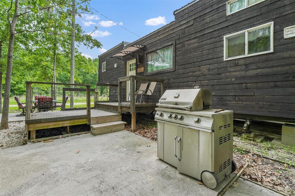 a backyard of a house with barbeque oven and outdoor seating