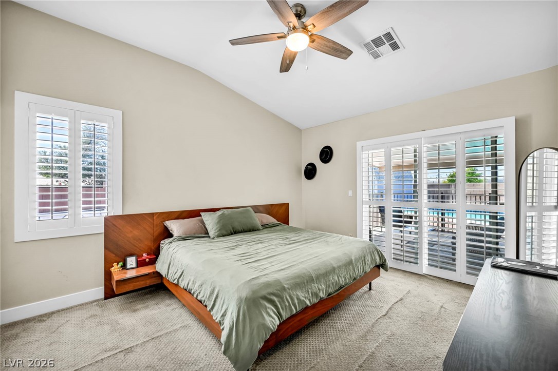 1234 Sunfire Street Henderson, NV 89014 - Photo 13 of 40 Natural light filters into this bedroom through wide windows and glass doors, enhancing the airy ambiance.