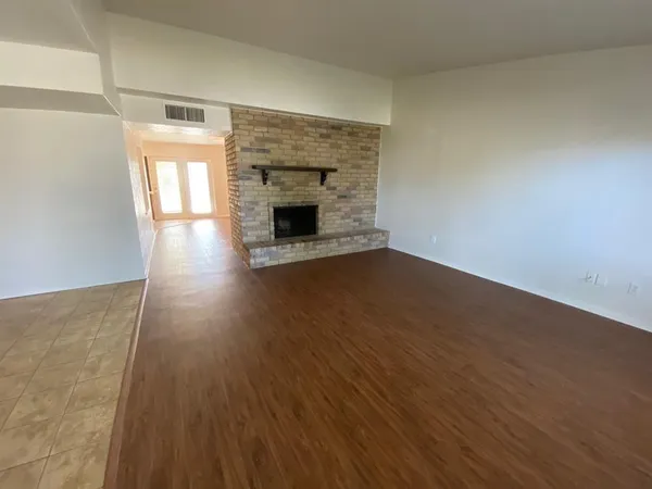 a view of empty room with wooden floor and fireplace