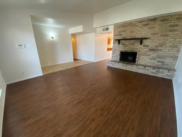 an empty room with wooden floor and fireplace