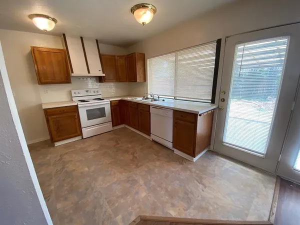 a kitchen with stainless steel appliances granite countertop a stove a sink and a refrigerator