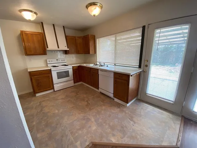 a kitchen with stainless steel appliances granite countertop a stove a sink and a refrigerator