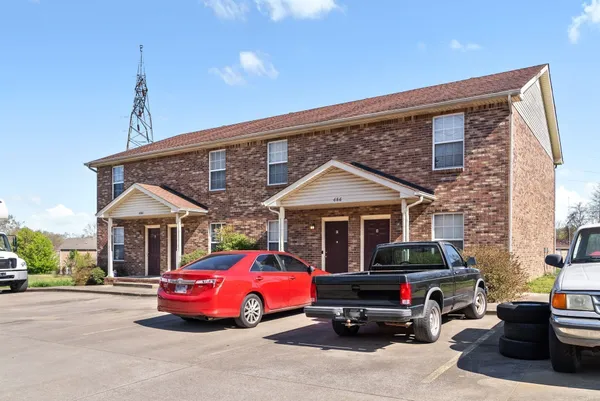 a front view of a house with cars parked