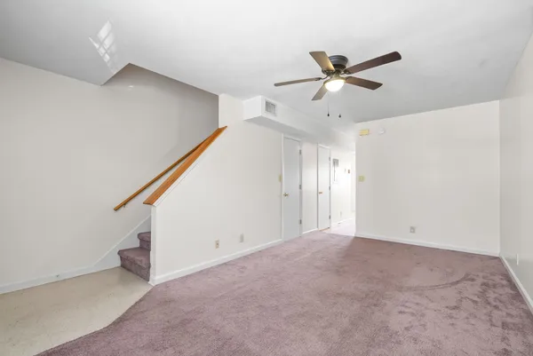a view of an empty room with a ceiling fan