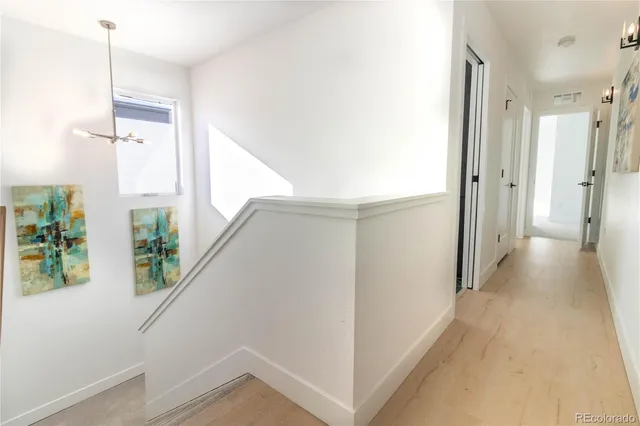 a view of a hallway with wooden floor and staircase