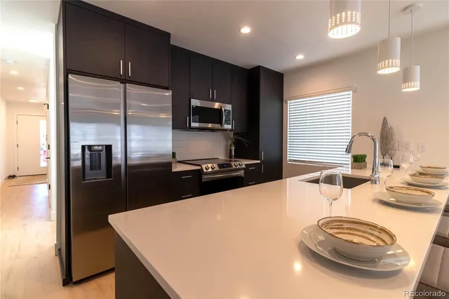a kitchen with stainless steel appliances a sink stove and refrigerator