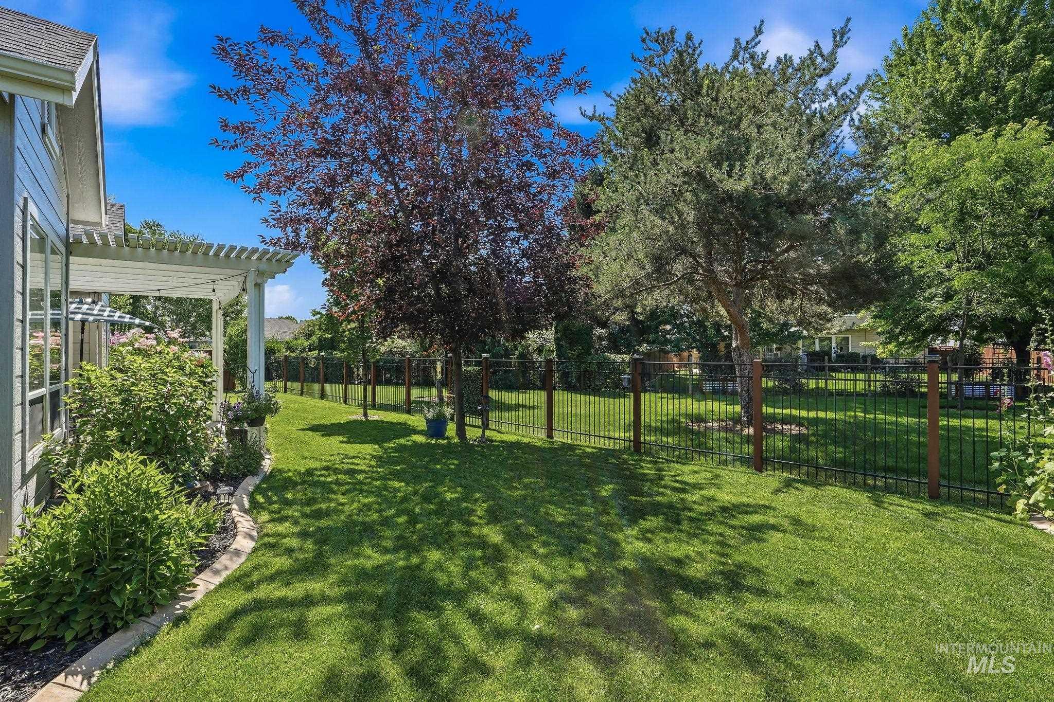 3969 North Hollymount Way Meridian, ID 83646 - Photo 41 of 47 Expansive lawn featuring mature trees and a black metal fence with wood posts