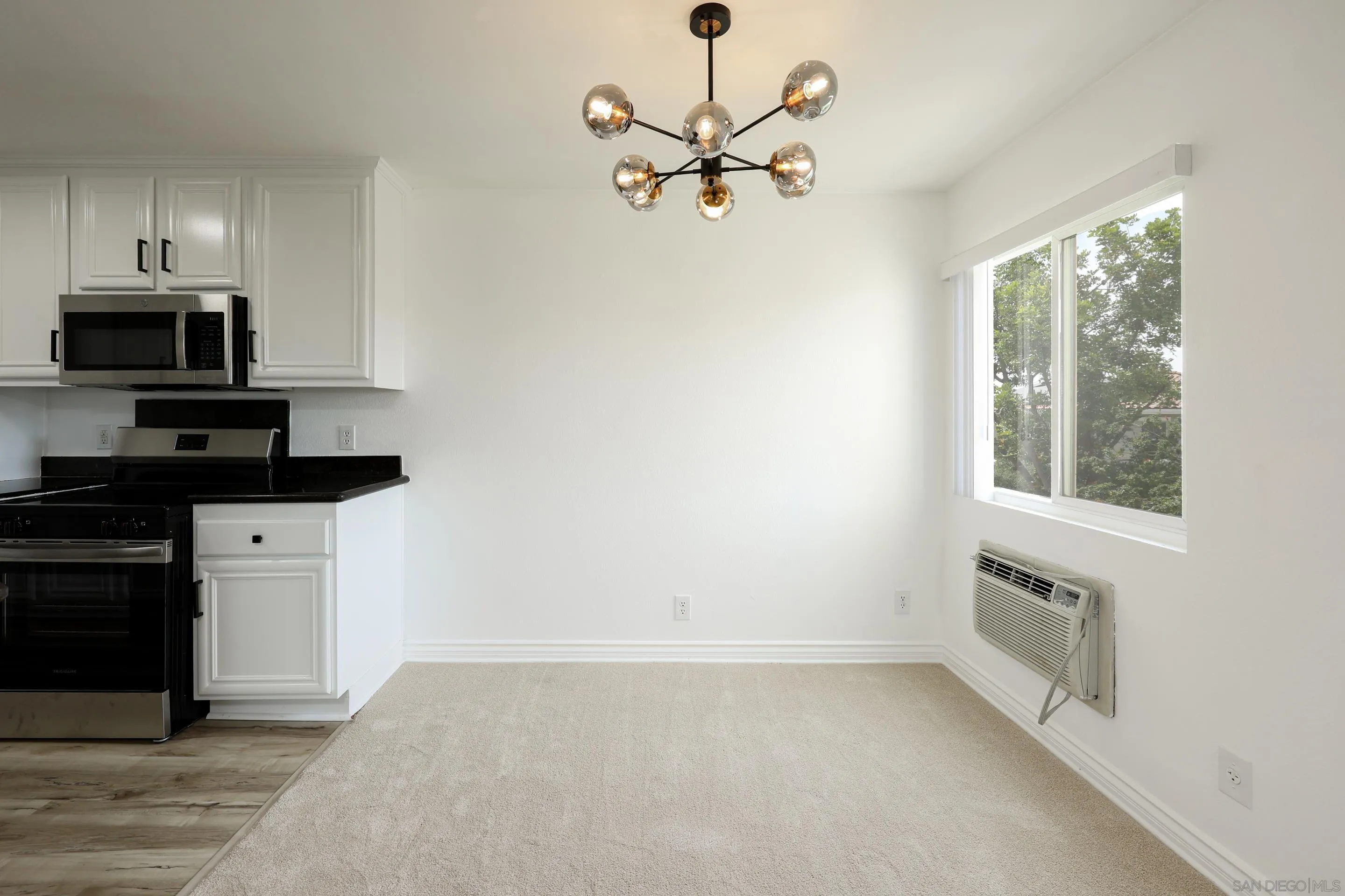 9949 Erma Road, Unit 203 San Diego, CA 92131 - Photo 11 of 43 a view of a kitchen with a stove a microwave and a ceiling fan