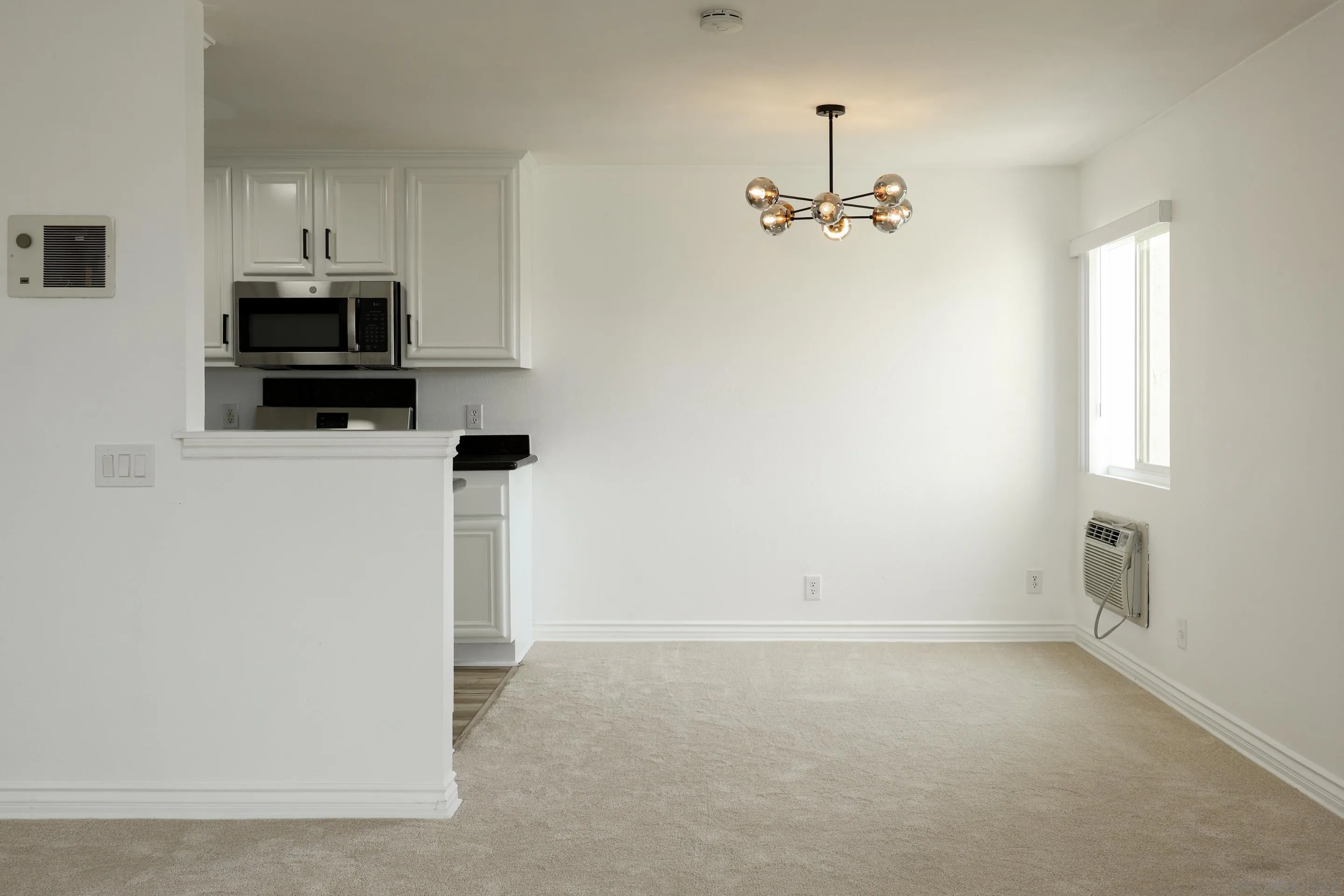 9949 Erma Road, Unit 203 San Diego, CA 92131 - Photo 12 of 43 an empty room with windows and cabinet