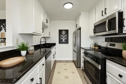 a kitchen with stainless steel appliances a stove microwave and sink