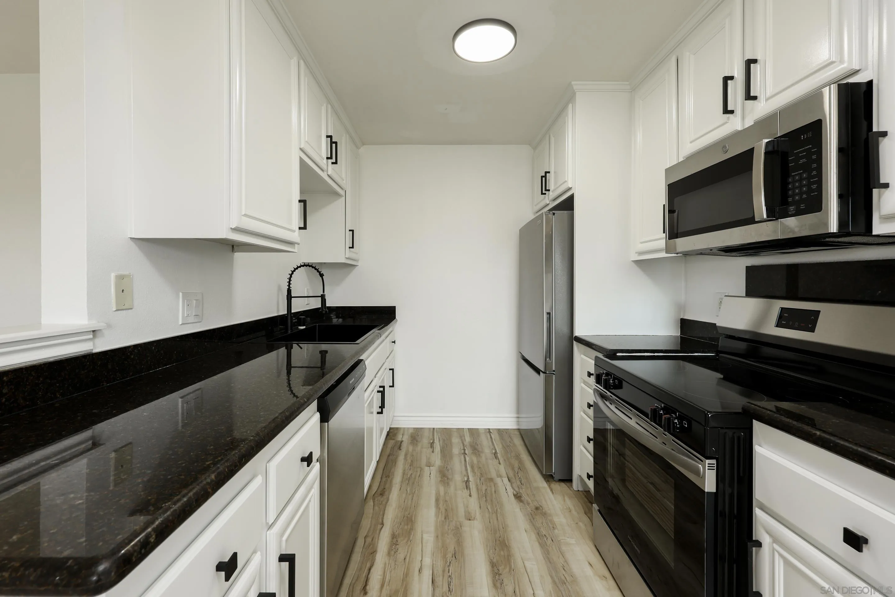 9949 Erma Road, Unit 203 San Diego, CA 92131 - Photo 15 of 43 a kitchen with stainless steel appliances a stove microwave and sink