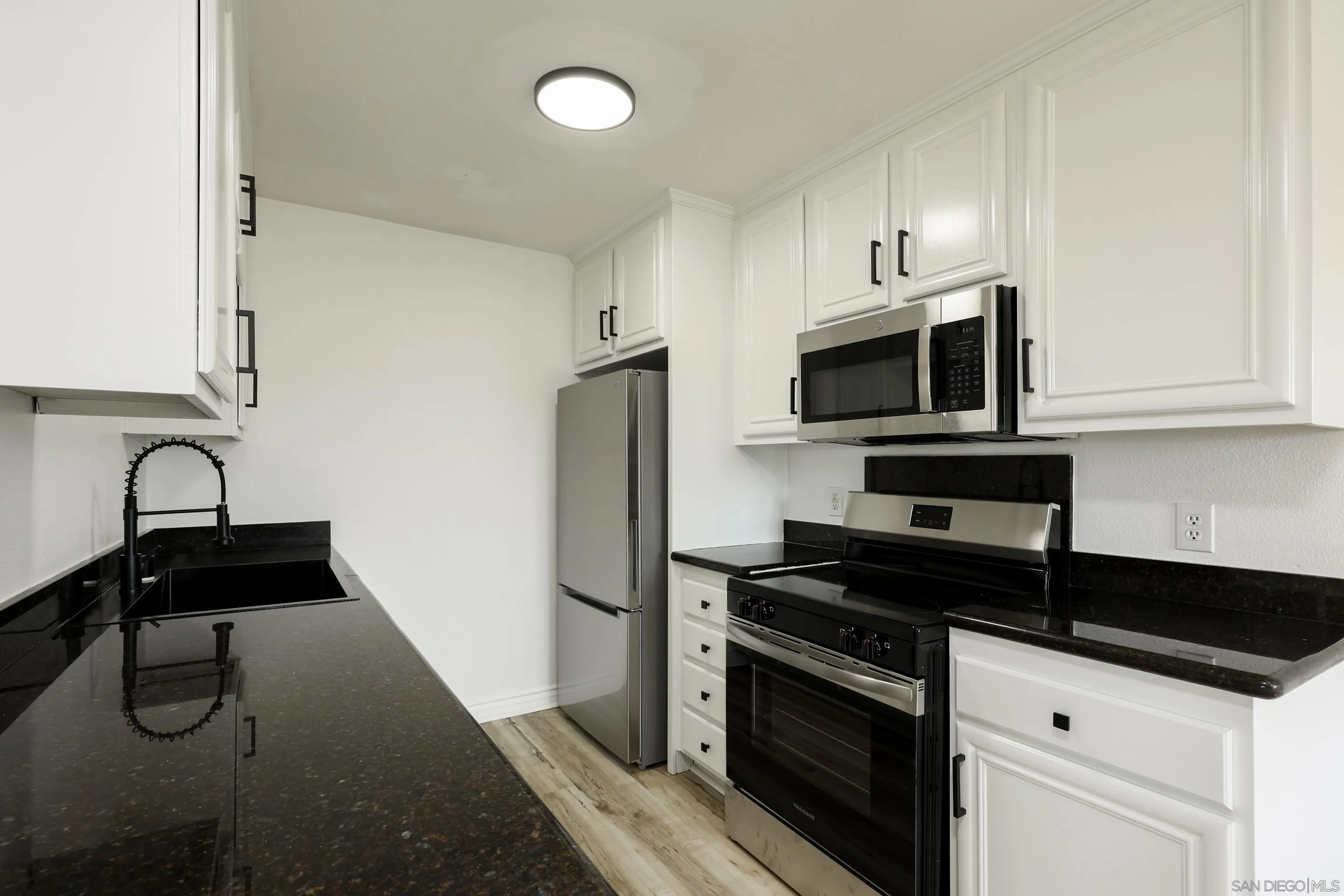 9949 Erma Road, Unit 203 San Diego, CA 92131 - Photo 16 of 43 a kitchen with stainless steel appliances a sink stove and refrigerator