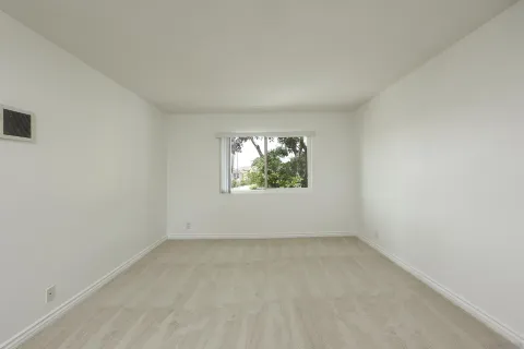 a view of empty room with kitchen