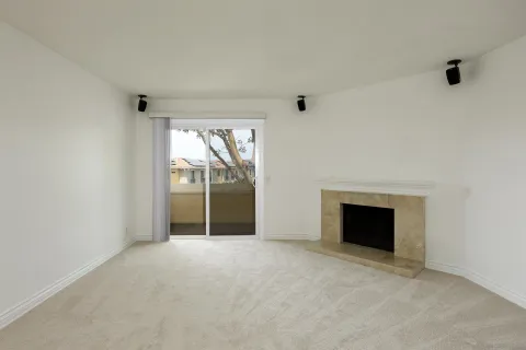 a view of an empty room with a fireplace and a window