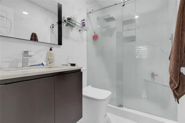 a bathroom with a sink a toilet and shower