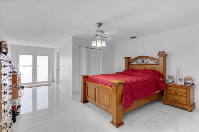 a spacious bedroom with a bed and a chandelier