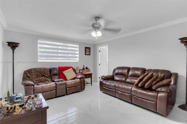 a living room with furniture ceiling fan and a window