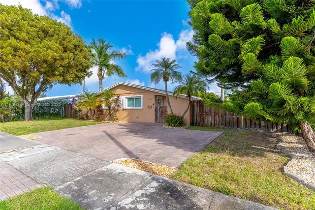 a front view of a house with a yard and a garden