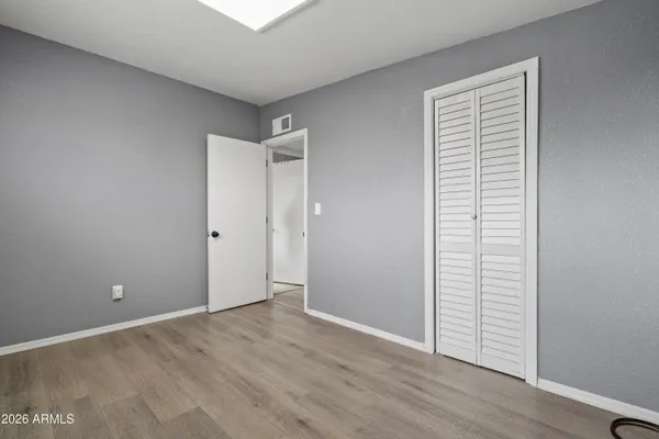 an empty room with wooden floor and closet