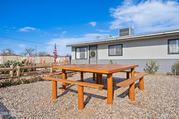 a backyard of a house with barbeque oven table and chairs