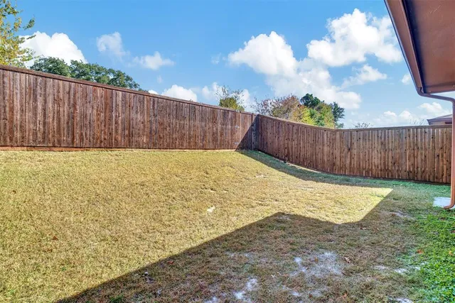 a view of a backyard with wooden fence