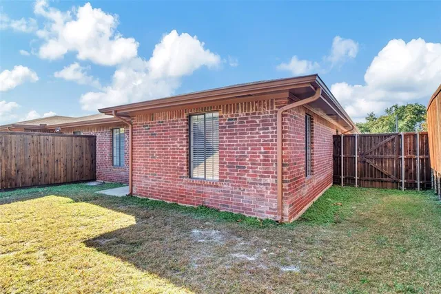 a view of a backyard with wooden fence