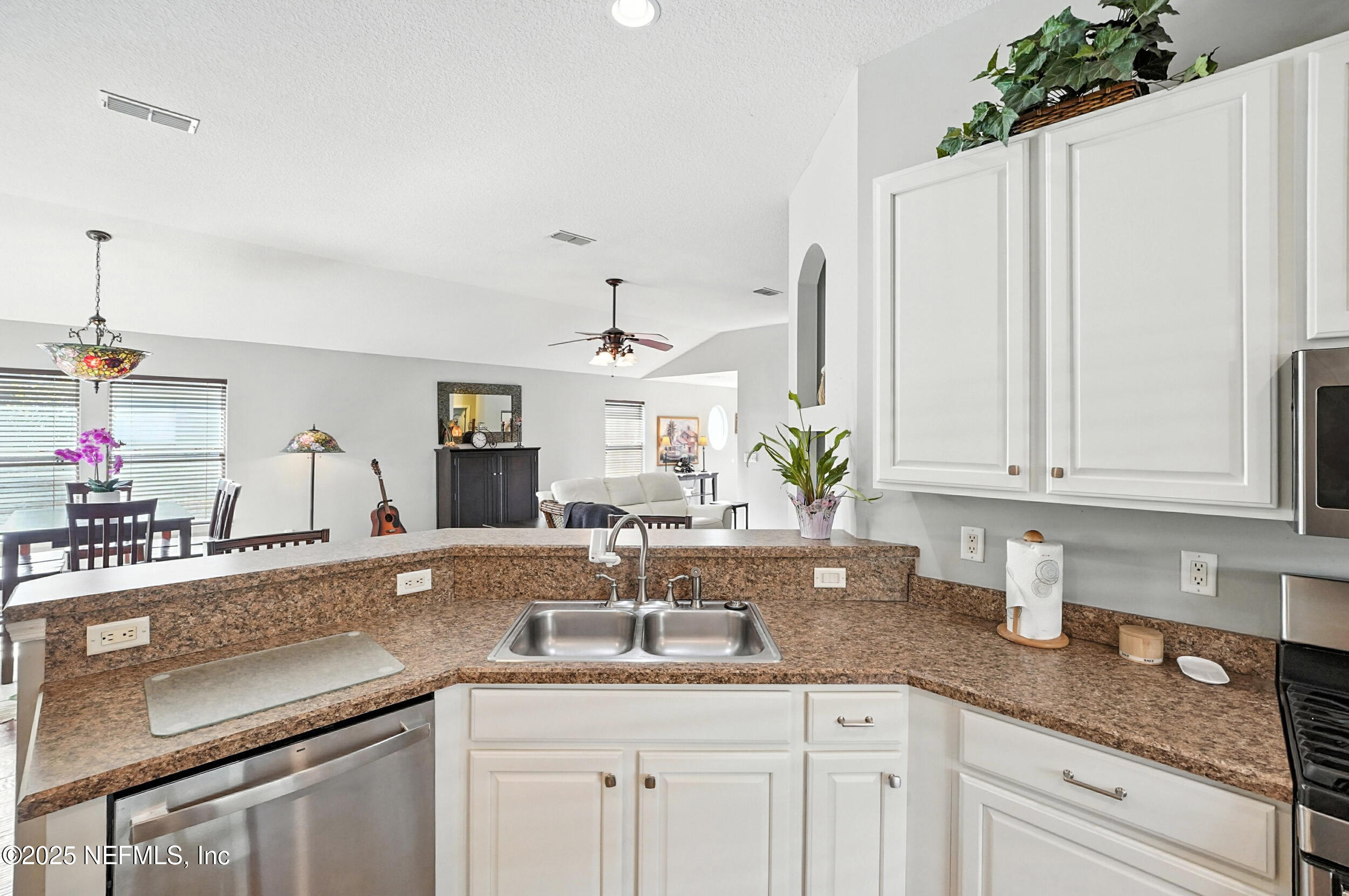 5877 Wind Cave Lane Jacksonville, FL 32258 - Photo 12 of 44 a kitchen with granite countertop a sink and white cabinets