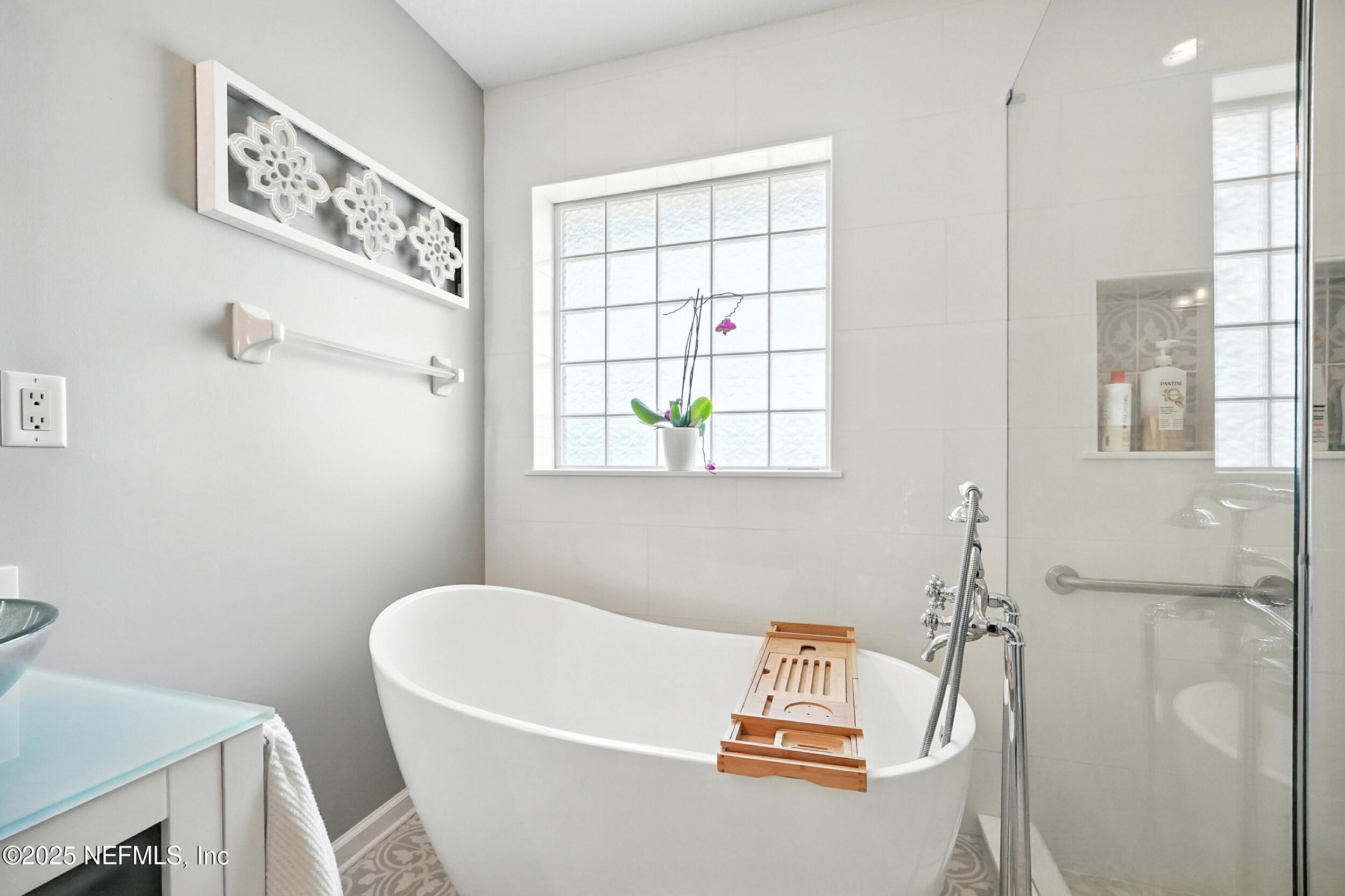 5877 Wind Cave Lane Jacksonville, FL 32258 - Photo 17 of 44 a bathroom with a bathtub a window and a shower