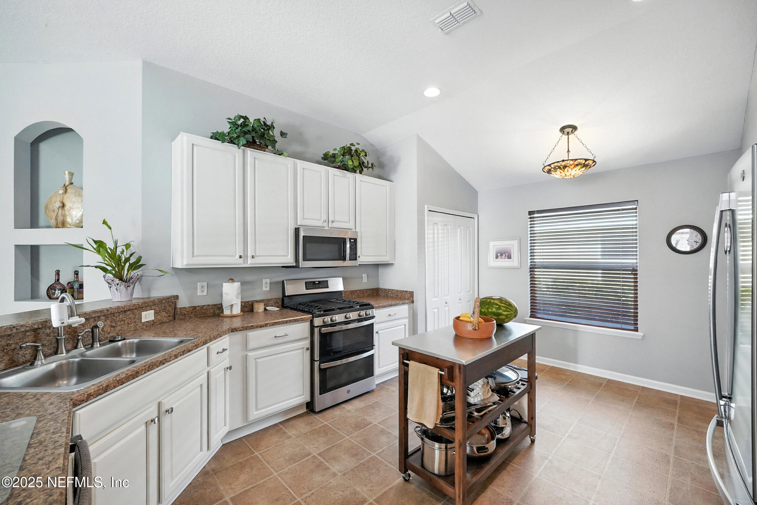 5877 Wind Cave Lane Jacksonville, FL 32258 - Photo 9 of 44 a kitchen with stainless steel appliances a stove a sink cabinets and a window