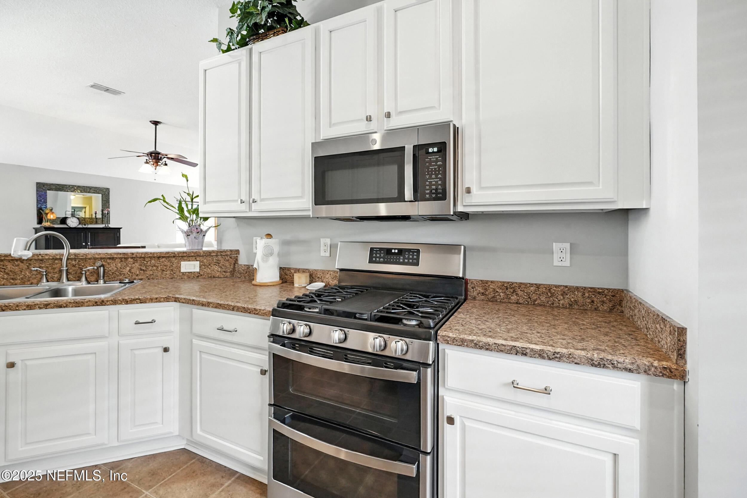 5877 Wind Cave Lane Jacksonville, FL 32258 - Photo 10 of 44 a kitchen with granite countertop white cabinets and a stove a oven with white countertops