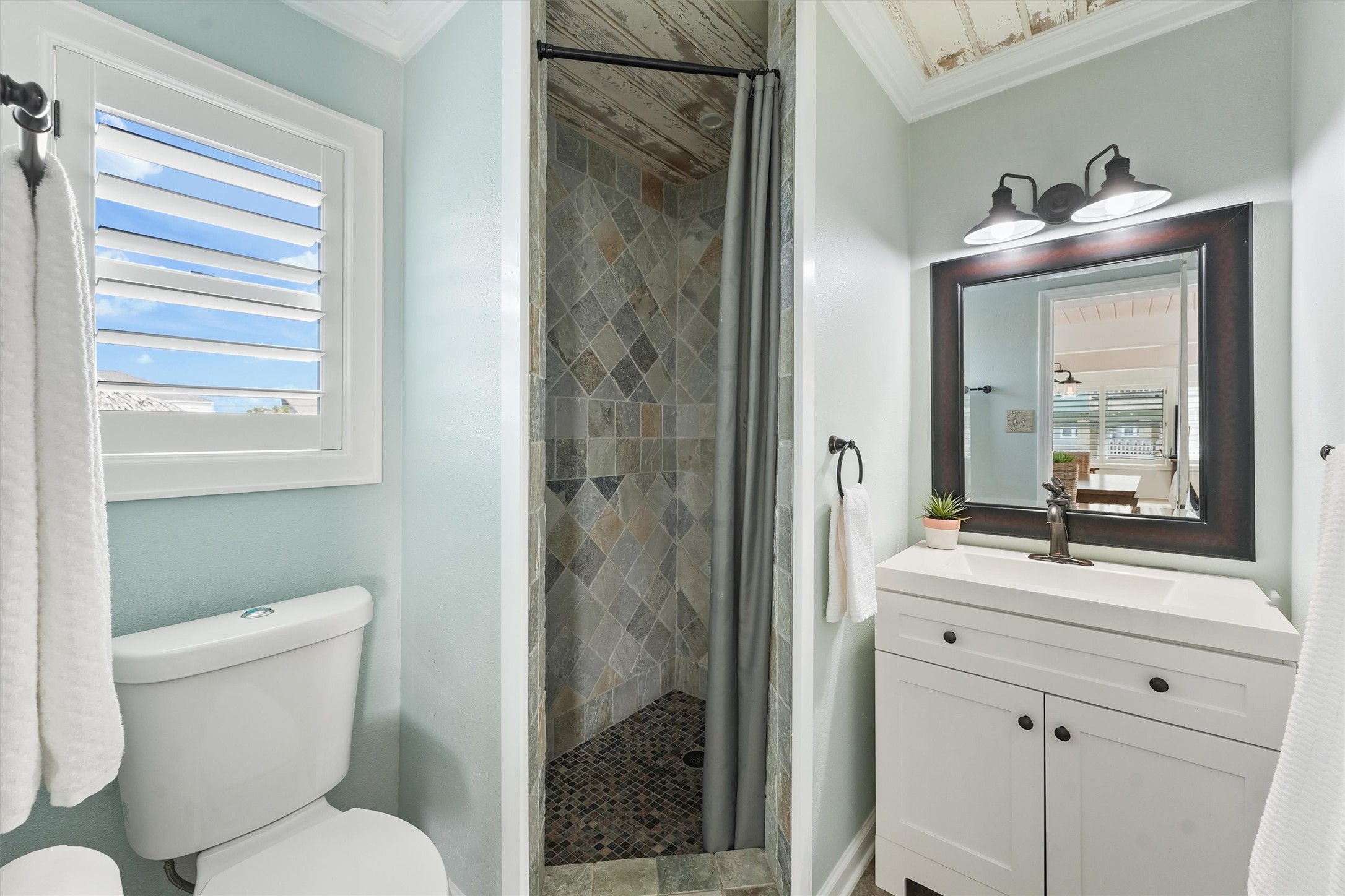 16634 Jamaica Beach Road Galveston, TX 77554 - Photo 24 of 47 a bathroom with a toilet sink vanity and mirror