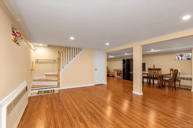 an empty room with wooden floor and entrance to ceiling window