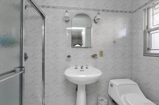 a bathroom with a toilet sink and mirror