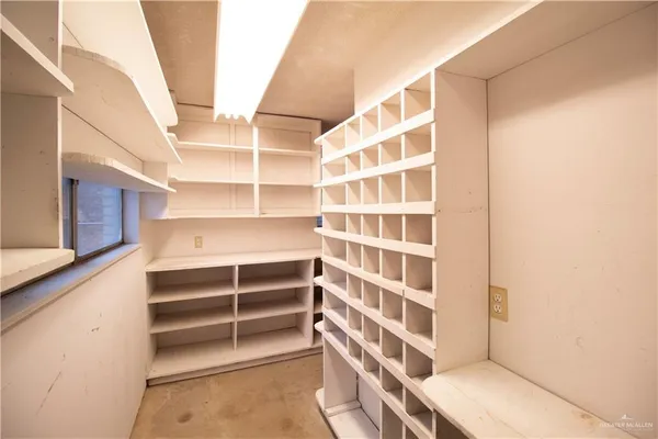 a view of walk in closet with empty racks