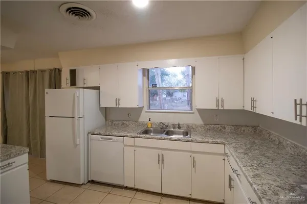 a kitchen with granite countertop cabinets and refrigerator